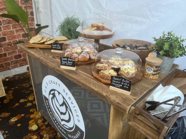 A rustic table showcasing a variety of baked goods and pastries under a white backdrop.