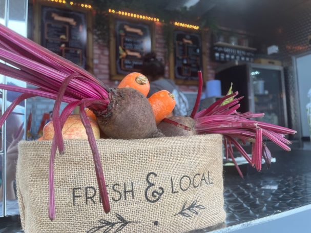 A basket of fresh vegetables, including beets and carrots, labelled 'Fresh & Local'.